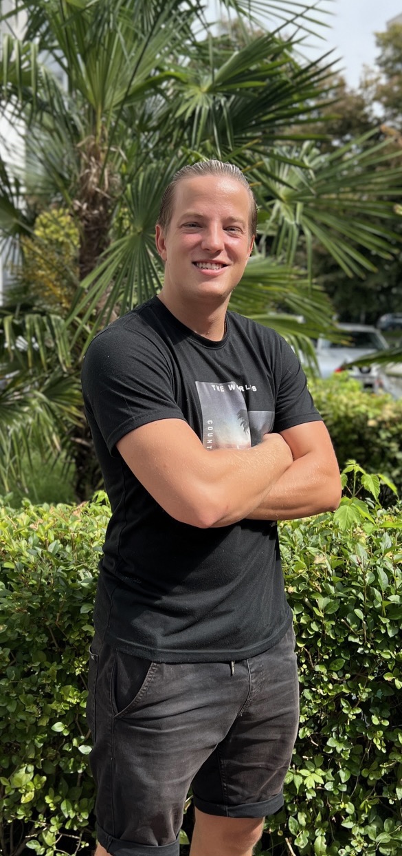 employee standing in front little palm tree